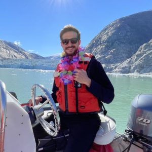 Josh Pelkey captains a Zodiac in Alaska. Josh is an expedition cruise travel advisor at Q Cruise + Travel Chicago. 